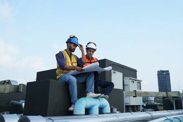 Foreman engineer and contractor worker wearing reflective jacket, helmet, resting from building...