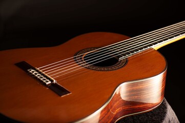 Classical Spanish flamenco guitar close up, dramatically lit isolated on black background with copy...