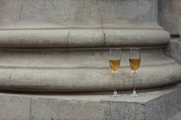 Two glasses of champagne at column city street outdoor. - 767210122