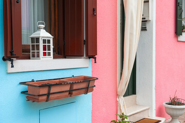 Blue and pink painted facade of the house. Colorful architecture in Burano, Italy.
