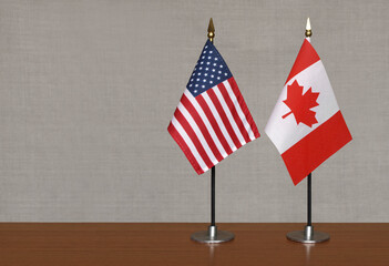 USA and Canada tabletop flags on gray blurred background