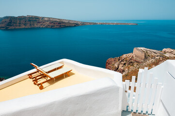 Santorini island, Greece. Two chaise lounges on the terrace with sea view.