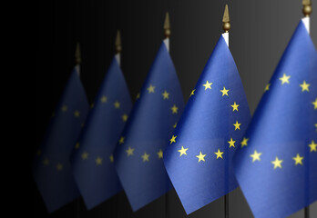 Row of EU flags on a dark background in perspective