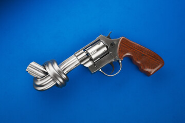 Symbolic Knotted Revolver on Blue Background - A Gun Control Statement