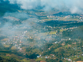 Aerial view of some Nepalese villages surrounded by nature and rice fields in the valleys at the...