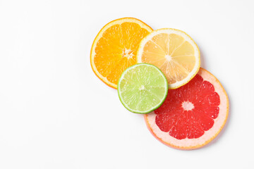 Slices of fresh ripe citrus fruits on white background, flat lay. Space for text