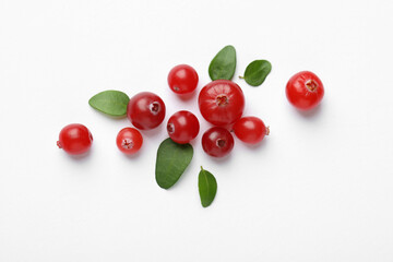 Fresh ripe cranberries and green leaves on white background, flat lay