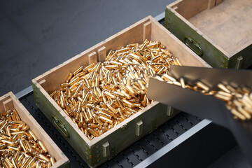 Streamlined Production: Ammunition Boxes with Gold Bullets on Conveyor Belt