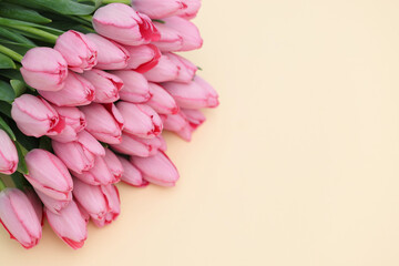 Bouquet of beautiful pink tulips on beige background, closeup. Space for text