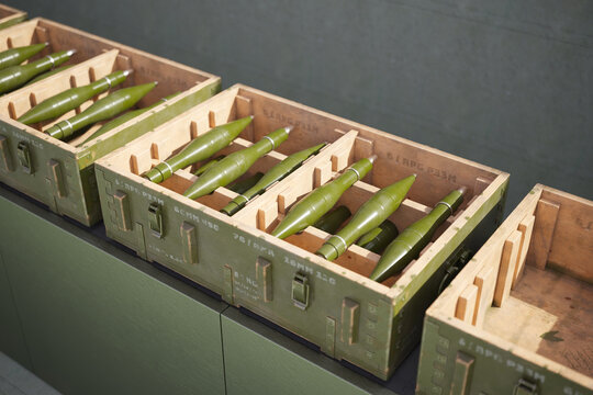 Display of Green Artillery Shells in Wooden Crates for Historical Exhibition
