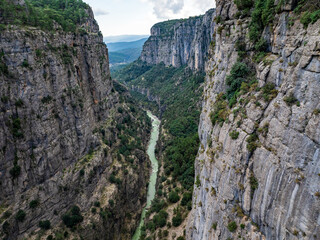 Dramatic view of the expansive Tazı Canyon gorge with lush greenery and a meandering river, seen from an aerial perspective in Turkey.