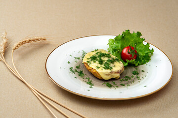 Baked potatoes with cheese and herbs on a plate