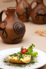 Baked potatoes with cheese and herbs on a plate and with wine