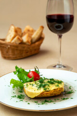 Baked potatoes with cheese and herbs on a plate and with red wine
