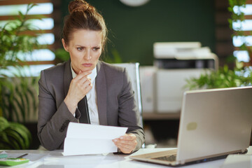 concerned modern woman employee in modern green office - 767224129