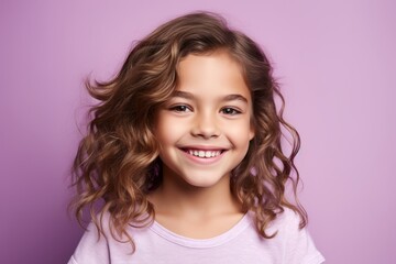 Portrait of a beautiful smiling little girl on a purple background.