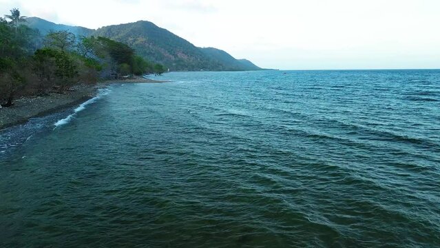 Experience the serene beauty of Palawan's coastline with this captivating drone footage. Fly along the shores of this majestic island, where the calm blue sea meets the lush greenery of the mountains.