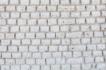 Handmade grey natural clay bricks  background texture with inclusions of shells and roots on a historic rural coastal cottage wall
