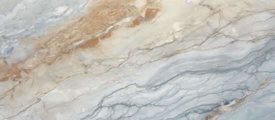 A closeup of a beige marble surface with a veined texture resembling water or wood grain. The...