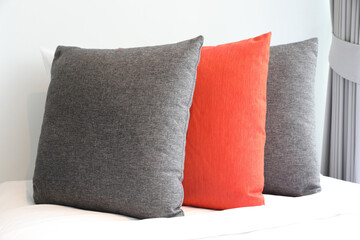 Gray and orange colored pillow with curtain
