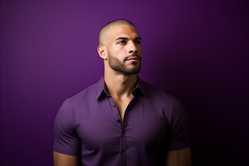 Portrait of a handsome young man in purple shirt over purple background