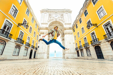 Happy tourist visiting Commerce Square with Rua Augusta Arch in Lisbon, Portugal.Happy tourist visiting Commerce Square with Rua Augusta Arch in Lisbon, Portugal.. - obrazy, fototapety, plakaty