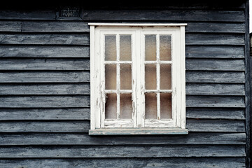 Old English wooden former Inn now derelict in a village location. The rough wooden panels and...