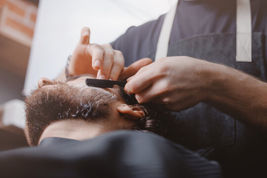 Shave with razor in barbershop, Man hipster in barber shop