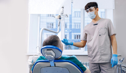 Professional young dental gives recommendations on oral care for male patient