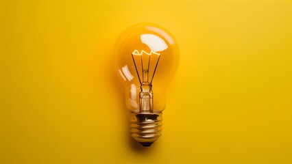 Innovative concept vibrant yellow background highlights illuminated light bulb - obrazy, fototapety, plakaty