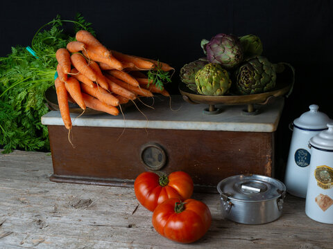 Verduras sobre una báscula, antigua con zanahorias, alcachofas, coliflor, brócoli, tomates, acelgas