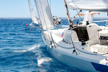 Competitive sailing yacht racing on blue sea
