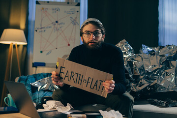 Supporting Pseudoscience: Man Holds Sign Asserting 'The Earth is Flat - obrazy, fototapety, plakaty
