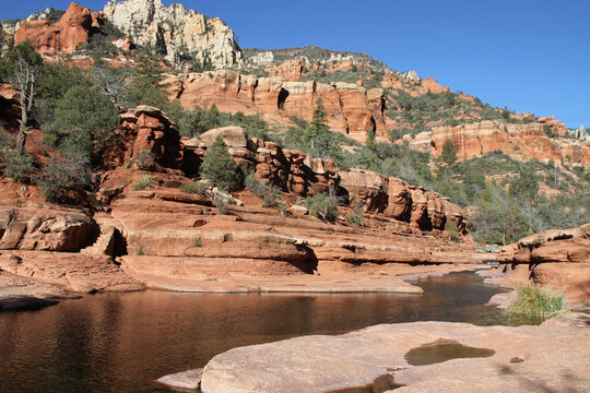 photo of beautiful red rock canyon near sedona and oak valley in arizona with reflections in creek