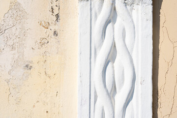 Close up detail of embossed border on wall with peeling paint on typical Greek facade in the...