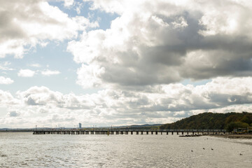 Molo nad morzem Bałtyckim pod pochmurnym niebem z przebijającym się słońcem © Sebastian