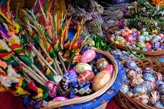 Beautiful handmade colorful Easter eggs in a basket and Easter palms on stall during fier. Kurpie, Poland