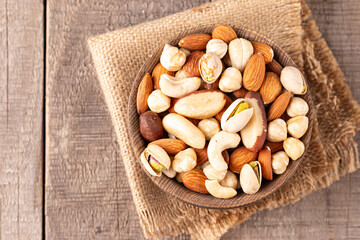 Healthy mix nuts on wooden background. Almonds, hazelnuts, cashews, peanuts, pistachios, Brazil nuts