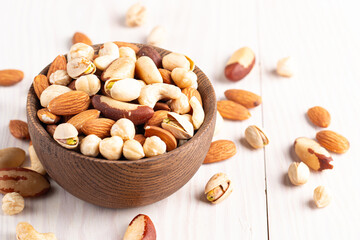 Healthy mix nuts on wooden background. Almonds, hazelnuts, cashews, peanuts, pistachios, Brazil nuts