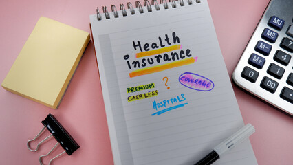 Concept of health insurance written on note pad while doing plan for insurance.