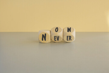Turned wooden cubes and changes the word never to now or vice versa. Beautiful beige background,...