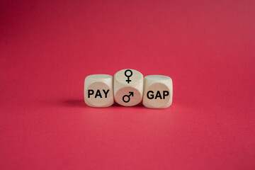 Pay gap symbol. Wooden cubes form the expression pay gap. Gender Difference Symbols. Beautiful red background