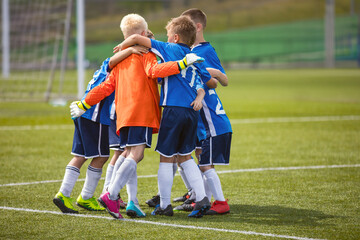 Happy Boys Jumping and Huddling Celebrating Winning Match. Children in Football Team Play the Tournament Game
