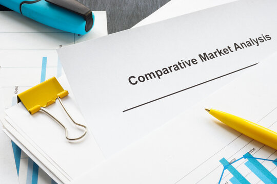 A comparative market analysis report from a stack of papers with graphs.