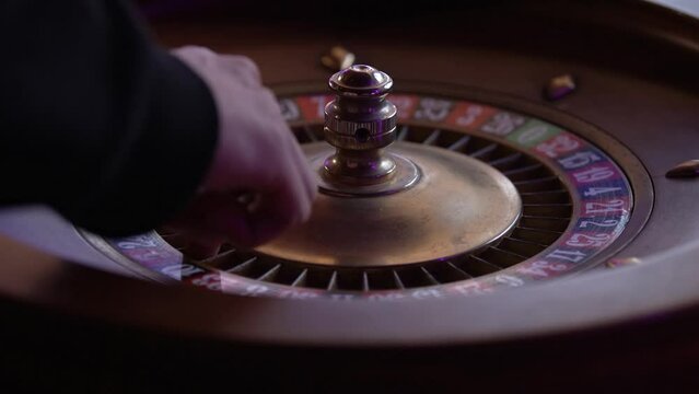 the croupier spins the classic wooden casino roulette
