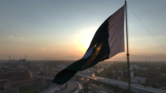 Big Flag of Pakistan in Peshawar in slow motion at sunset time, evening. Bala Hisar Fort Peshawar Pakistan, Drone Aerial