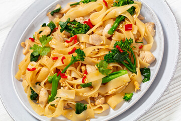 rice noodles with chicken, eggs, chinese broccoli