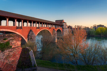 wonderful view of Ponte Coperto (covered bridge) is a bridge over the Ticino river in Pavia at...