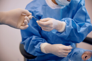 Close up of medical experts during patient's eye surgery at ophthalmology clinic.