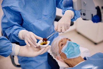 Close up of surgeon using iodine for sterilization in operating room at eye clinic.